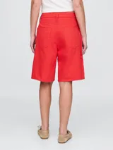 Short de jean de corte recto y largo hasta la rodilla, con diseño clásico de cinco bolsillos y cierre frontal con botón y cremallera.