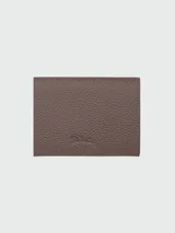 Billetera compacta Longchamp modelo Le Foulonné, confeccionada en cuero granulado color marrón topo, con diseño plegable y cierre de botón a presión.