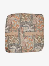 Pañuelo cuadrado de tela liviana con diseño estampado estilo patchwork que combina motivos florales y paisley en tonos tierra, naranja y azul sobre fondo crema.