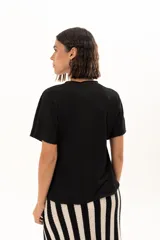 Blusa de textura arrugada en color negro, con cuello redondo y mangas cortas de corte holgado.