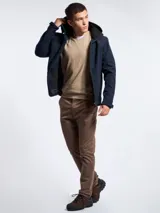Campera de abrigo tipo softshell color azul marino, con capucha, cierre frontal y bolsillos laterales con cierre. Presenta interior en color negro y ajuste en los puños.
