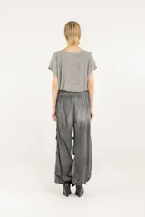 Pantalón amplio de popelina de algodón y satén de viscosa, en tono gris con efecto de teñido en frío. Presenta cintura elastizada, diseño de pierna ancha con frunces laterales y cordón de ajuste en el ruedo que permite fruncirlo en los tobillos.