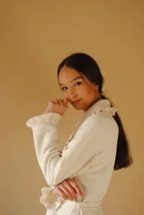 Bata larga color blanco, confeccionada en algodón capitoneado con diseño de espiga. Presenta volados en el cuello y puños, y lazo de ajuste en la cintura.