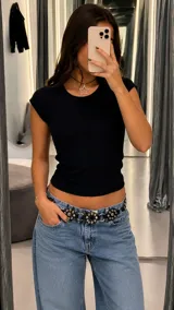 Top de mujer de tejido acanalado en color negro, con cuello redondo y mangas cortas estilo casquillo, de corte ajustado al cuerpo.