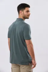 Remera polo de manga corta en color azul melange, con cuello camisero, cierre frontal de dos botones y pequeño bordado en el pecho.