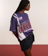 Remera oversized de tule con estampado geométrico en tonos azul y borgoña. Presenta cuello redondo, mangas cortas y estampado frontal con letras.