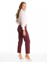 Pantalón de corte entallado y largo cropped, confeccionado en tejido con elasticidad técnica resistente a las arrugas. Presenta una pretina ancha y plana para un ajuste cómodo, bolsillos simulados en el frente y en la parte posterior, y pequeñas aberturas laterales en el ruedo.