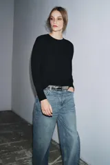 Jersey de punto liso color verde, con cuello redondo y manga larga. Confeccionado en lana suave.