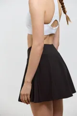 Pollera deportiva corta con calza incorporada, diseñada para actividades como pádel o tenis. Cuenta con cintura ancha de ajuste cómodo y bolsillo invertido en la calza para guardar pelotas. Confeccionada en tejido liviano y elastizado.