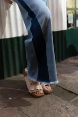 Pantalón de denim tiro alto con corte wide leg, lavado medio con desgastado suave, costuras clásicas y terminación en ruedo deshilachado. Diseño de panel lateral en tono más oscuro.