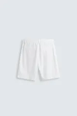 Bermuda azul marino de corte regular fit, confeccionada en tejido de algodón y lino. Cuenta con bolsillos frontales y traseros, cierre frontal con cremallera y botón.