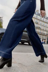 Botín de tacón alto en bloque con cuerpo de cuero sintético y caña de tejido elástico acanalado. Presenta punta redonda y diseño minimalista.