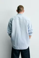 Camisa relaxed fit de denim ligero color celeste, con cuello solapa, manga larga con puños abotonados y cierre frontal de botonadura. Confeccionada con una mezcla de lino y algodón con efecto lavado.