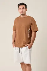 Bermuda de friza color gris melange, de corte suelto, con cintura elástica y cordón de ajuste negro.