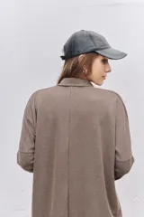 Vestido corto de tejido acanalado color marrón chocolate, con cuello polo y cierre frontal de botones. Presenta mangas largas con puños ajustados y un corte holgado.