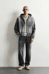 Pantalón de jean corte slim fit con efecto lavado, tiro medio, cinco bolsillos y cierre frontal con cremallera y botón.