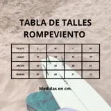 Rompevientos gris y negro de tela náutica, con cierre escondido en cuello alto y tres bolsillos de gran capacidad.