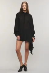Camisa negra de crepé liviano y translúcido, de calce regular, diseño asimétrico con volados en el lado izquierdo, mangas largas con puños elásticos y volados, cuello redondo y cierre frontal con cartera oculta y botones metálicos.