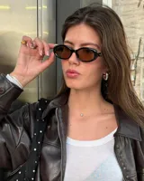 Lentes de sol unisex con montura ovalada negra y cristales marrones.