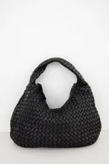 Bolso tipo hobo de cuero marrón oscuro, con diseño trenzado y asa integrada al hombro.