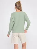 Buzo de punto calado color verde militar, de silueta relajada, con escote redondo a la base y mangas largas de hombro caído.