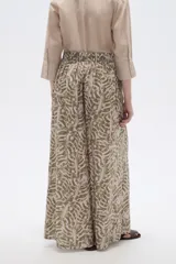 Pantalón de poliéster ancho con estampado botánico en tonos verde militar y beige, de tiro alto.