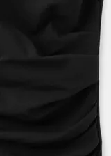 Vestido midi negro con escote halter, diseño sin mangas y detalle drapeado en la cintura.