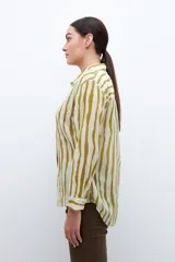 Camisa de manga larga con estampado a rayas verticales en tonos pistacho y blanco, con cuello clásico y cierre frontal con botones.