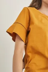 Remera celeste de algodón peinado, con cuello redondo y mangas cortas con detalle de calado.