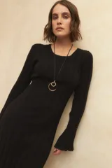 Vestido midi de punto acanalado en color gris, con mangas largas acampanadas y aberturas laterales en el ruedo. Presenta un diseño ajustado al cuerpo.