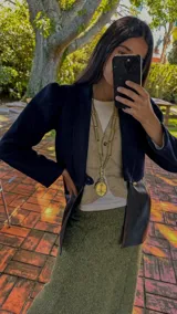 Cadena de eslabones plateados con un dije colgante que representa el Escudo Nacional Argentino enmarcado en una corona de laurel.