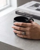 Anillo de plata 925 con diseño calado y detalles de esmalte negro.