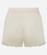 Minishort satinado de tiro medio color beige, con pinzas delanteras, bolsillos y detalle de encaje en el ruedo.