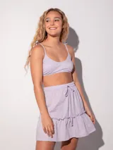 Top de bikini negro brillante con tirantes finos ajustables y cierre trasero con broche.