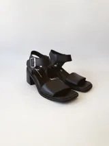 Sandalias de cuero negro con taco cuadrado de 6cm y tira ancha sobre los dedos.