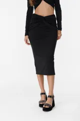 Falda midi negra de corte ajustado, con detalle drapeado y abertura lateral.