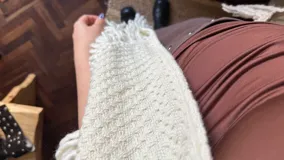 Ruana de lana merino color marfil, tejida a mano, con diseño triangular y flecos largos en los bordes.