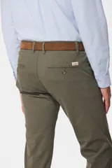 Pantalón de gabardina color marrón claro, corte slim fit, con bolsillos laterales y traseros. Se ajusta a la cintura con cinturón de cuero marrón.