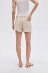Short de algodón beige con diseño a rayas verticales y pequeño estampado de flores, con bolsillos laterales y cierre frontal con botón y cremallera.