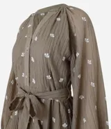 Vestido largo evasê color marrón con estampado de flores blancas, cuello en V, mangas largas abullonadas y cinturón de lazo.