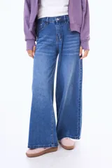 Jean de corte wide leg en color azul medio con efecto lavado. Presenta tiro medio, cierre frontal con botón y bolsillos laterales y traseros.