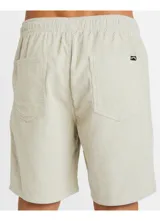 Bermuda Billabong modelo Larry Cord, de color beige, confeccionada en corduroy. Presenta un diseño clásico con bolsillos y un pequeño logo bordado en la parte inferior de la pierna izquierda.