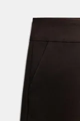 Shorts de tiro medio en color crudo, con bolsillos laterales delanteros y cierre frontal con cremallera y ganchos metálicos.