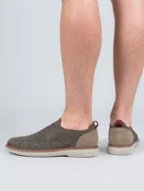 Zapato tipo slip on Hush Puppies modelo Apolo, confeccionado en tejido de poliéster color gris con refuerzo de gamuza en el talón y detalle de tirador rojo. Cuenta con suela de EVA Comfort Flex.