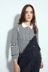 Remera de manga larga a rayas verticales verdes y blancas, con cuello polo y cierre frontal de botones. Presenta un diseño ajustado al cuerpo.