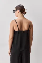 Top negro de breteles finos con escote en V y diseño minimalista, confeccionado en tela fluida y suave.