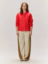 Camisa de lino liviano color tostado, con silueta relajada, cuello mao, alforzas verticales frontales, mangas con volumen y puños elastizados con volados.
