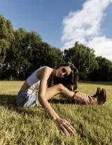 Botas de cuero color marrón y blanco con bordados negros, de estilo cowboy con taco bajo.