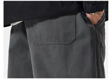 Pantalón cargo ancho de algodón gabardina color beige claro, con cintura elástica y regulable, y múltiples bolsillos cargo con pliegues en las piernas.