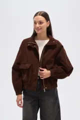 Campera corta marrón de pana, con cuello alto, cierre frontal con broches a presión, bolsillos plaqué con solapa y puños elásticos.